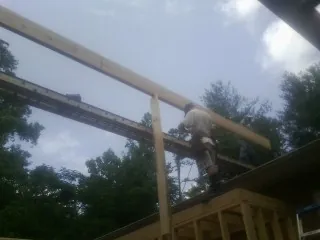 Carpenter setting a ridge beam over a new addition frame — Ice Dam Removal by Roofing Brothers in Kirkersville