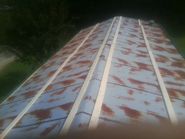 Rusted metal roof panels with new wood purlins before replacement — Storm Damage Roof Repair in Kirkersville by Roofing Brothers