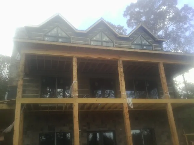 Dormers and porch framing on a large log home under construction — Roof Coating work by our crew in Kirkersville