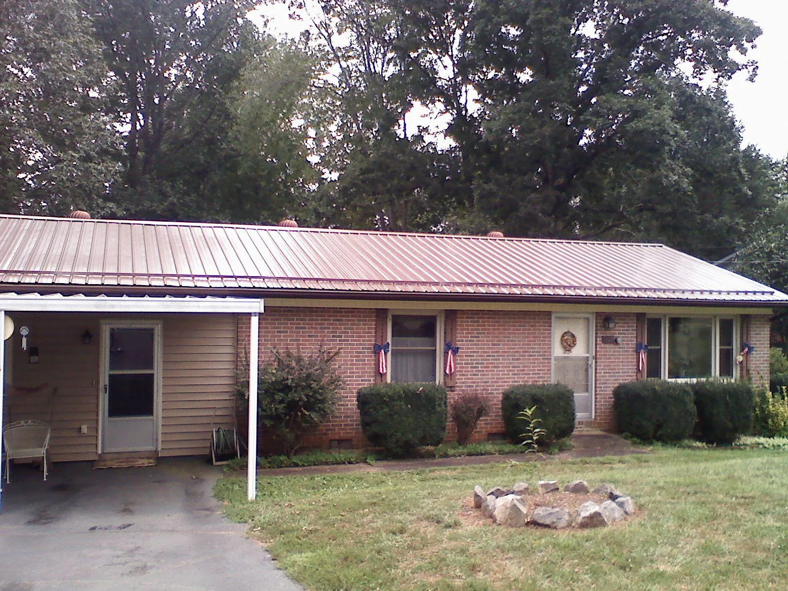 Bronze metal roof and carport on a brick ranch home — Roof Repair work by our crew in Kirkersville